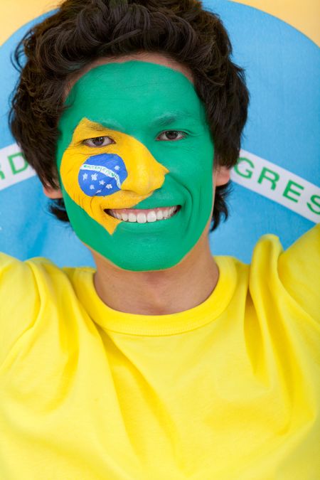 Portrait of a man with the Brazilian flag painted on his face