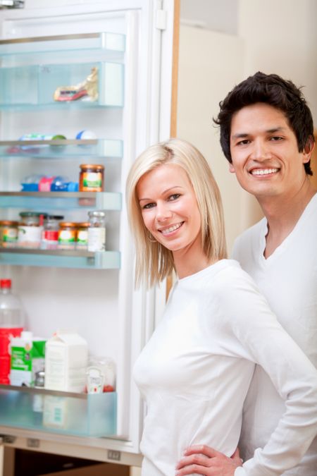 Couple at home looking inside the fridge and smiling