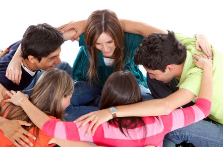 Group of friends sitting on the floor and hugging - isolated over a white background