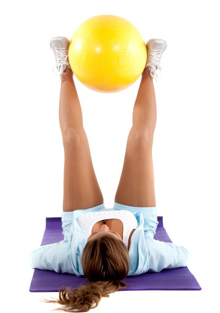 Woman exercising with a pilates ball - isolated over a white background