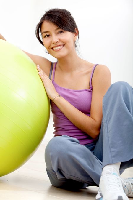 fitness woman leaning on a pilates ball and smiling