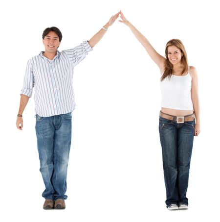 Beautiful couple portrait smiling with arms up and their hands together isolated over white