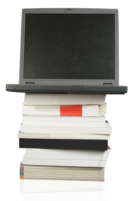 laptop on top of a pile of books