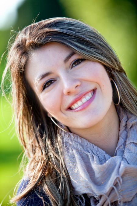 Portrait of a beautiful young woman outdoors smiling