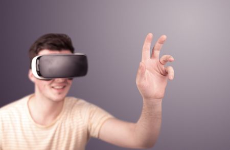 Young impressed man wearing virtual reality goggles