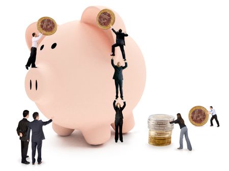 Business people putting savings on a piggy bank - isolated