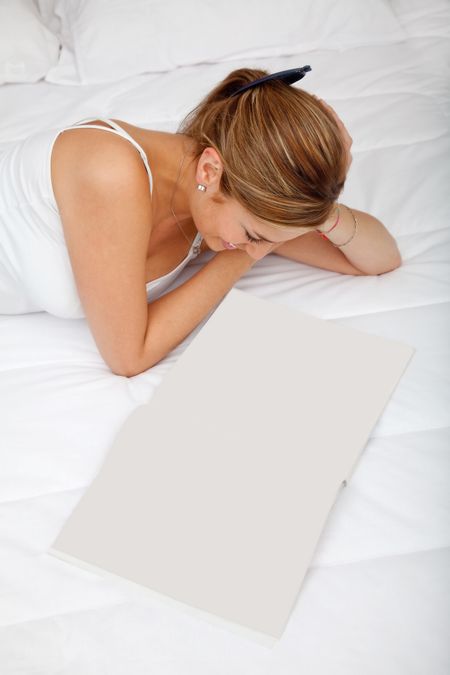 Woman lying on the bed and reading a book