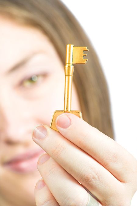 Woman holding the key of success in focus over a white background