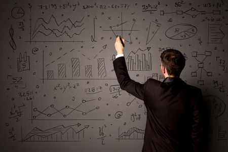 Young businessman in black suit standing in front of detailed calculations 