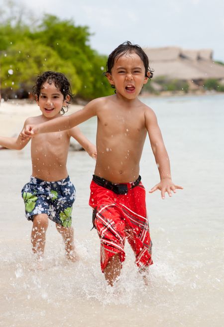 Kids running at the beach enjoying their holidays	
