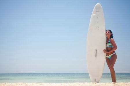 Female surfer with his surfboard at the beach