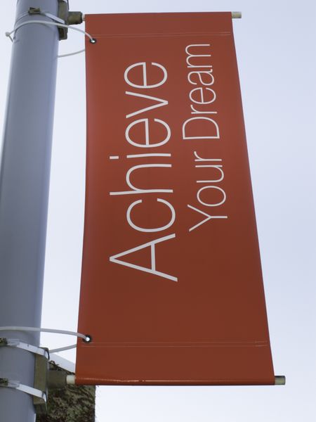 Motivational banner on campus of community college: Achieve Your Dream