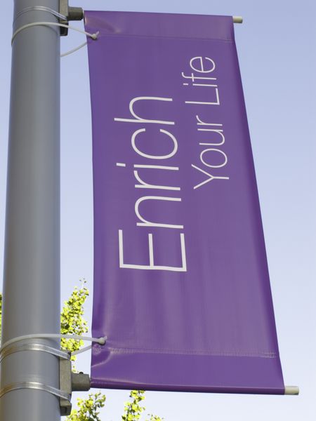 Motivational banner on campus of community college: Enrich Your Life