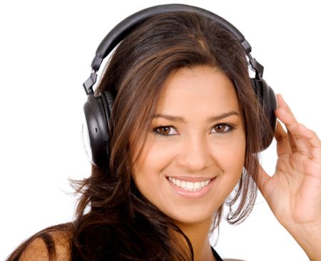 pretty girl listening to music on her headphones smiling - isolated over a white background