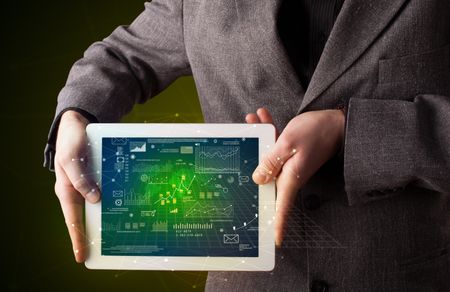 Casual businessman holding tablet with strategy and business related graphics 