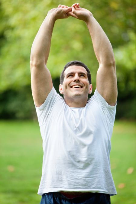 Handsome man stretching at the park - fitness concepts