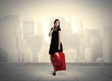 A stylish female standing with red shopping bags on platform and city view landscape backround concept