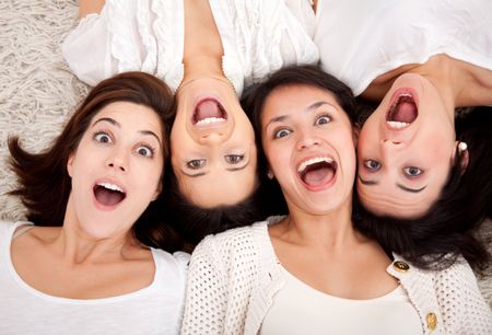 Group of surprised women lying on the floor making faces