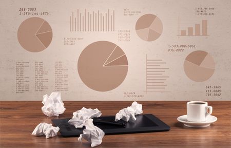 Graphic business office desk with pie charts and graphs on the brown sepia background wall