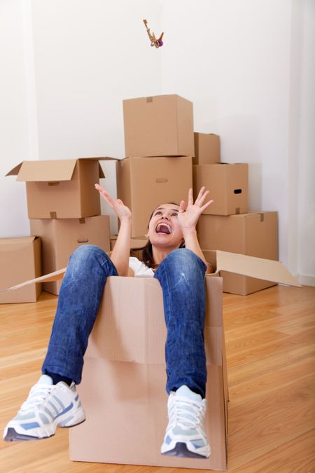 Woman inside a cardboard box excited about moving