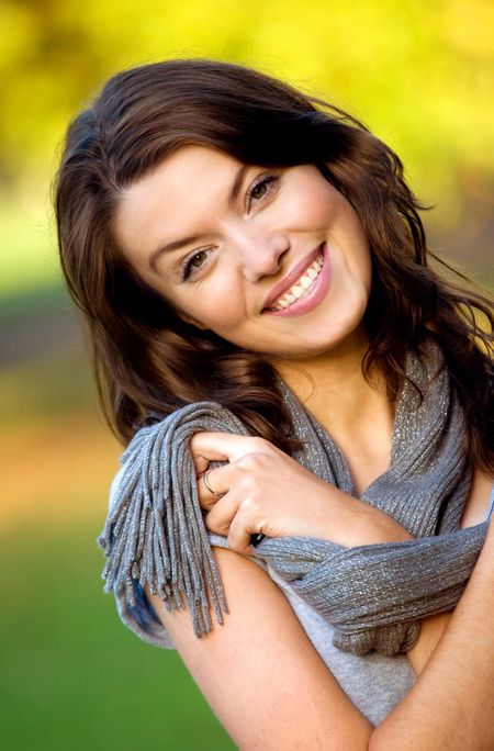 beautiful female portrait outdoors smiling and playing with her scarf