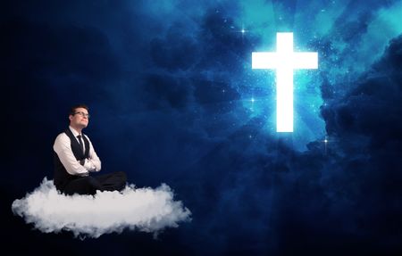 Caucasian businessman sitting on a white fluffy cloud looking and wondering at a big bright glowing cross