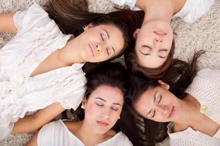 Group of women lying on the floor with eyes closed
