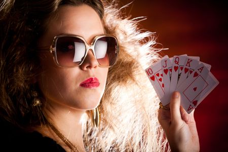 Stylish female poker player holding a royal flush