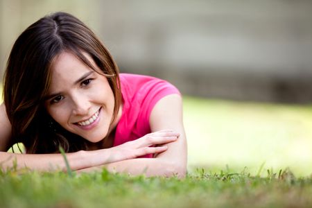 Beautiful girl lying on the floor outdoors and smiling