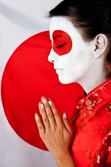 Woman making a prayer for Japan with the flag painted on her face