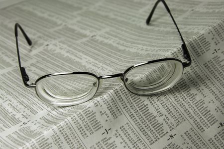 Pair of eyeglasses on financial page of daily newspaper