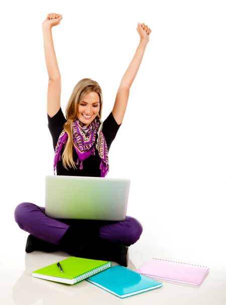 Happy female student with a laptop and arms up