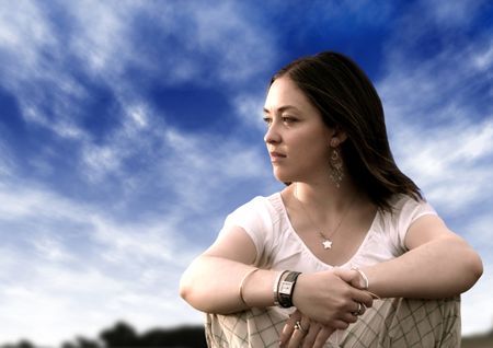 Pensive woman with a blue sky on the background