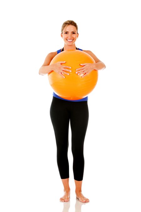 Sportive woman with a pilates ball - isolated over white
