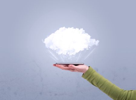 A male hand holding a mobile phone from profile view with an empty white cloud above the device for sales concept