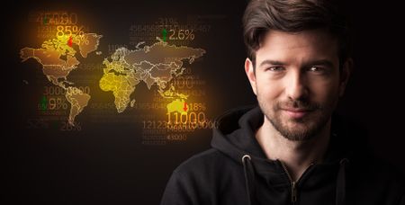 Portrait of a young businessman with a world map and numbers next to him on a dark background