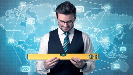 Businessman holding tool with global map graphic on the background
