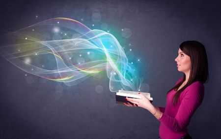 Casual young woman holding book with rainbow waves flying out of it