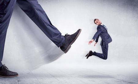 Giant leg kicking small businessman and he is flying away
