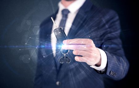 Businessman in suit holding over a key with connection concept around
