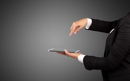 Female hand in suit holding tablet with no wallpaper
