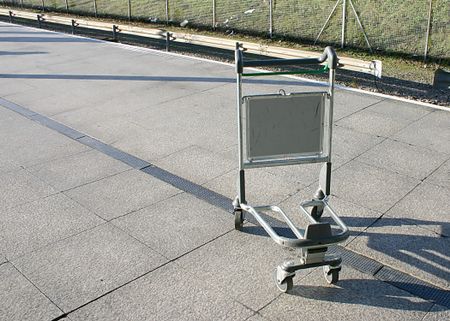 An abandoned trolley by the railway at an airport