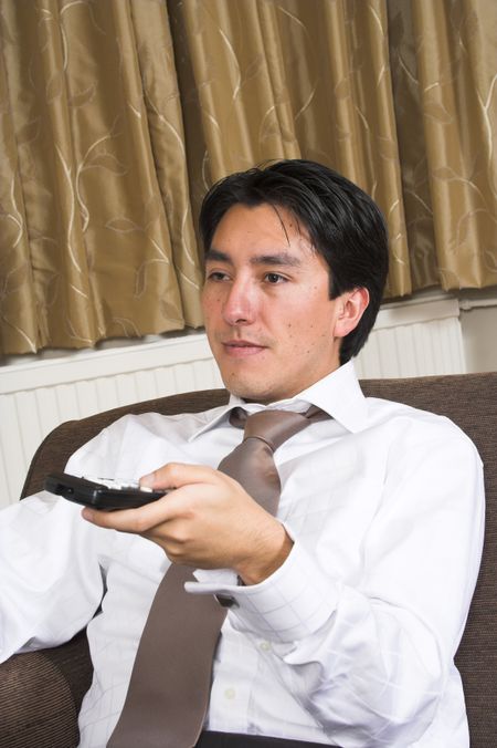 business man sitting on a sofa with a remote control