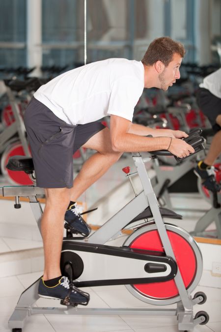 Athletic man on excercise bike at the gym