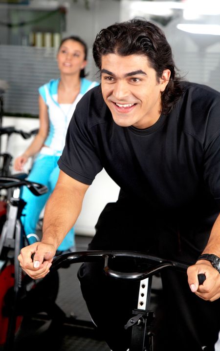 man looking happy while cycling at the gym
