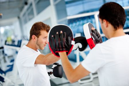 Male boxer at the gym with his trainer