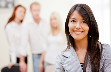 Business woman smiling with a group behind her