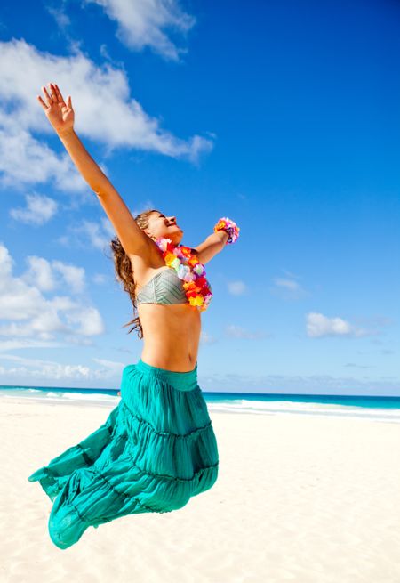 Happy Hawaiian woman at the beach jumping