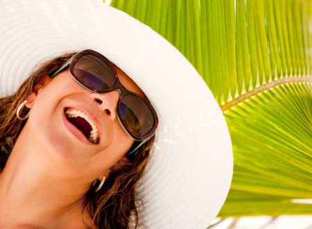Happy summery woman wearing a hat and sunglasses