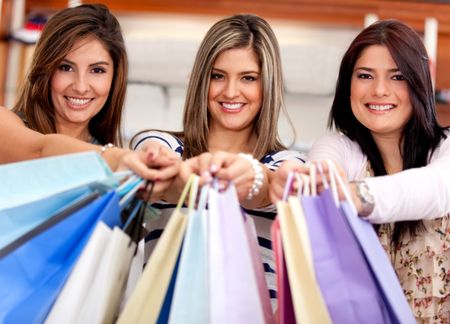 Happy group of shopping women holding bags at a store
